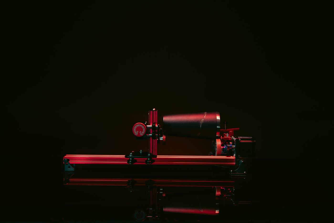 PiBurn V rotary holding a tumbler, lit red against a dark background
