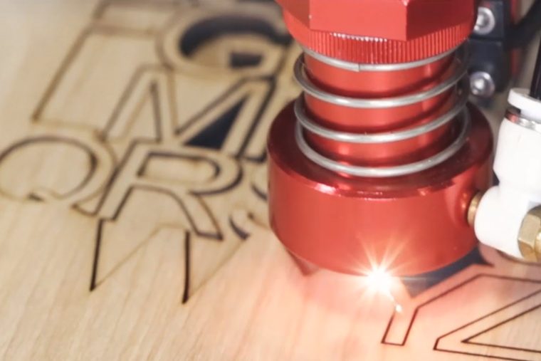 Boss CO2 laser head vector cutting letter shapes from birch plywood