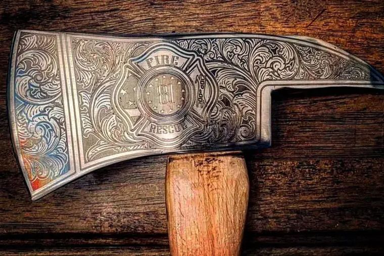 Ornate laser-engraved filigree covering a firefighter axe head
